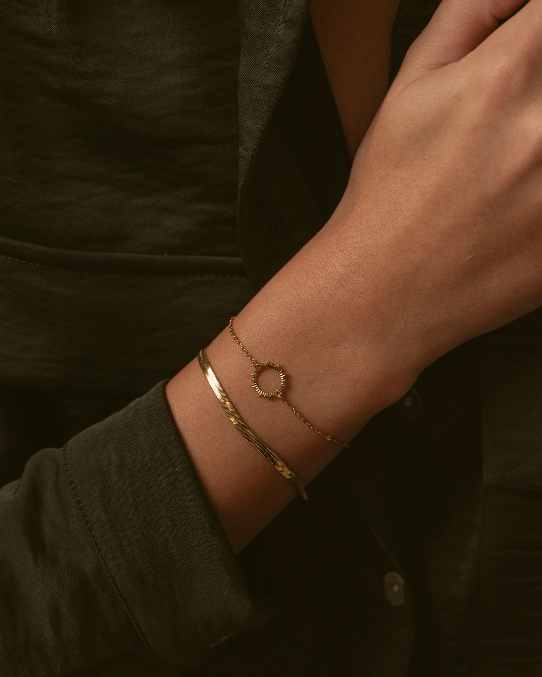 Association de deux bracelets made in France, composée d'un bracelet fin avec un soleil ajouré, et d'un bracelet en chaîne plate en plaqué or 3 microns 18 carats.