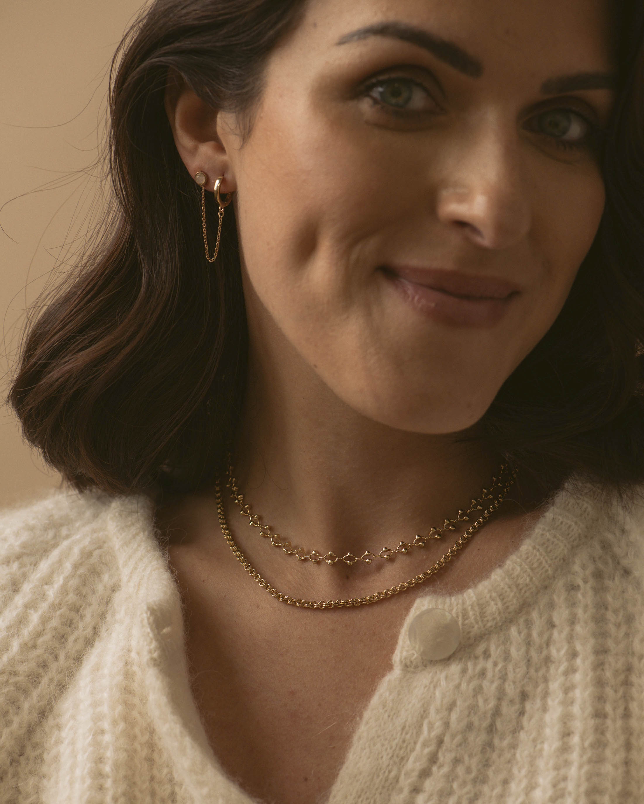 Combinaison de bijoux charmants, composée d'un collier ras de cou en chaîne avec des mailles ovales ornées de petites perles dorées, d'un collier en chaîne épaisse avec des mailles rondes, et d'une boucle en chaîne accrochée à une petite puce d'oreille en quartz rose, en plaqué or 18 carats made in France.