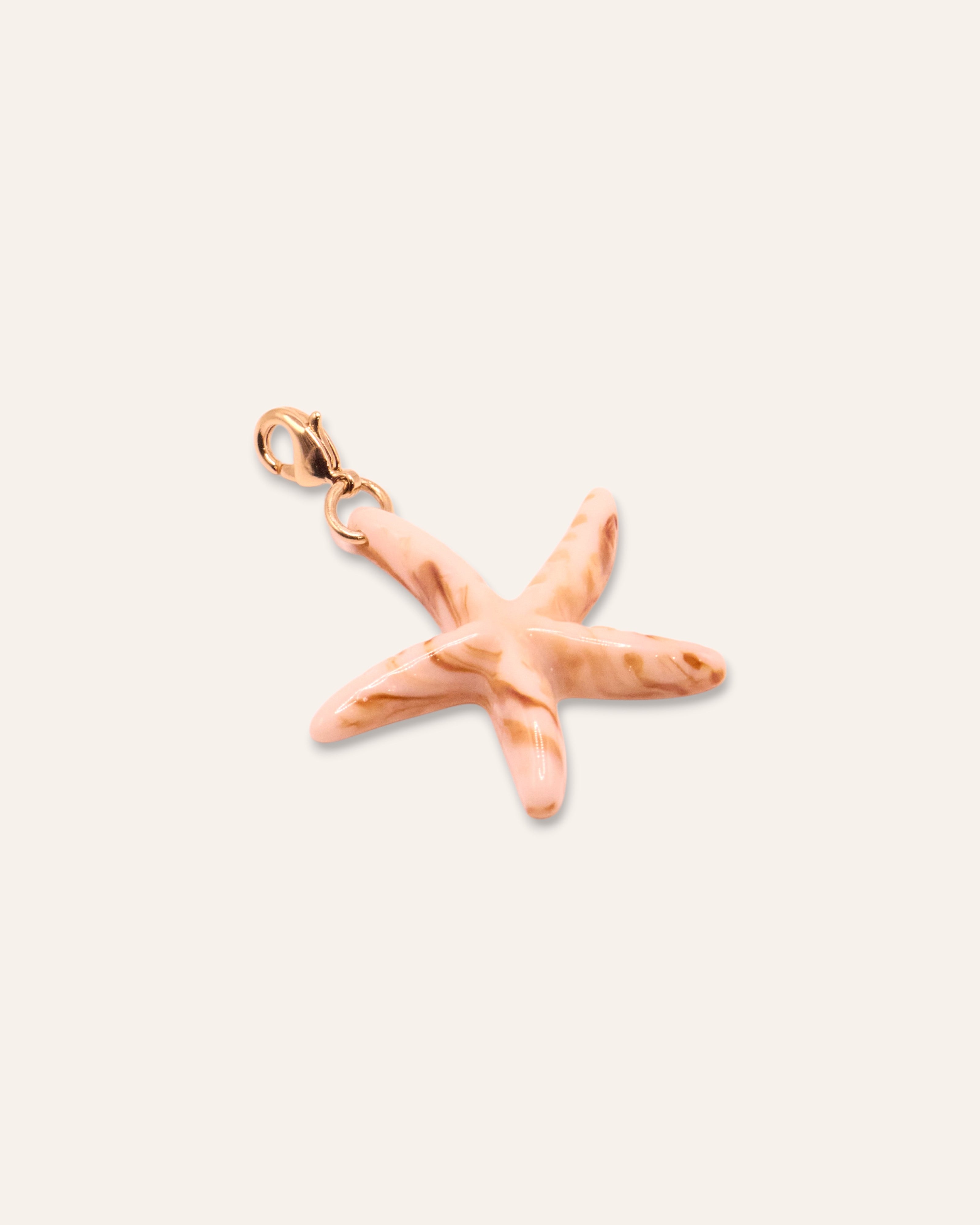 Aglaia beige marbled resin starfish pendant with gold-plated clasp. Unique, artisanal beach-inspired jewelry.
