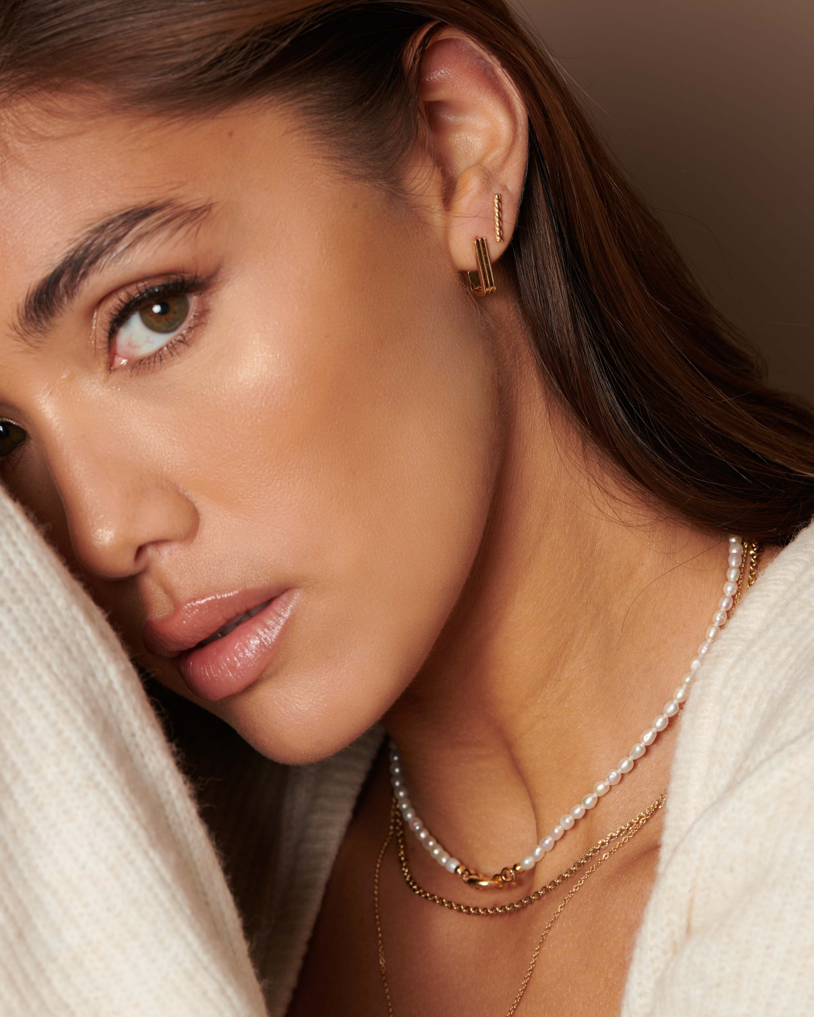 Jewellery set comprising a rectangular stripe-motif earring, a bar stud, a cultured-pearl necklace, and a sun-link chain, Made in France.