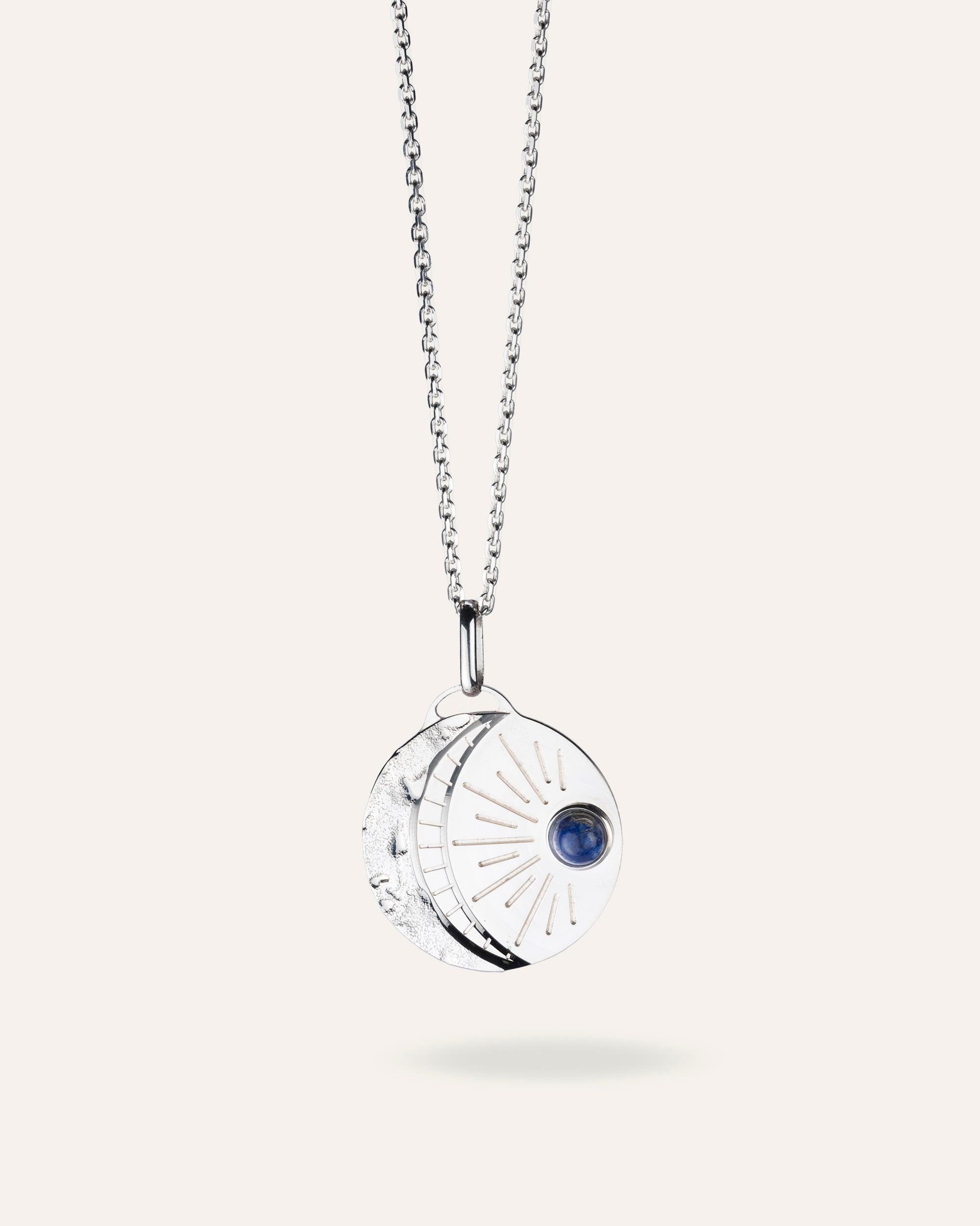 Collier en argent massif 925, chaîne forçat et médaille composée d'un croissant de lune martelé et d'un soleil représenté par une petite pierre ronde de Lapis Lazuli, laissant briller quelques rayons, made in France.