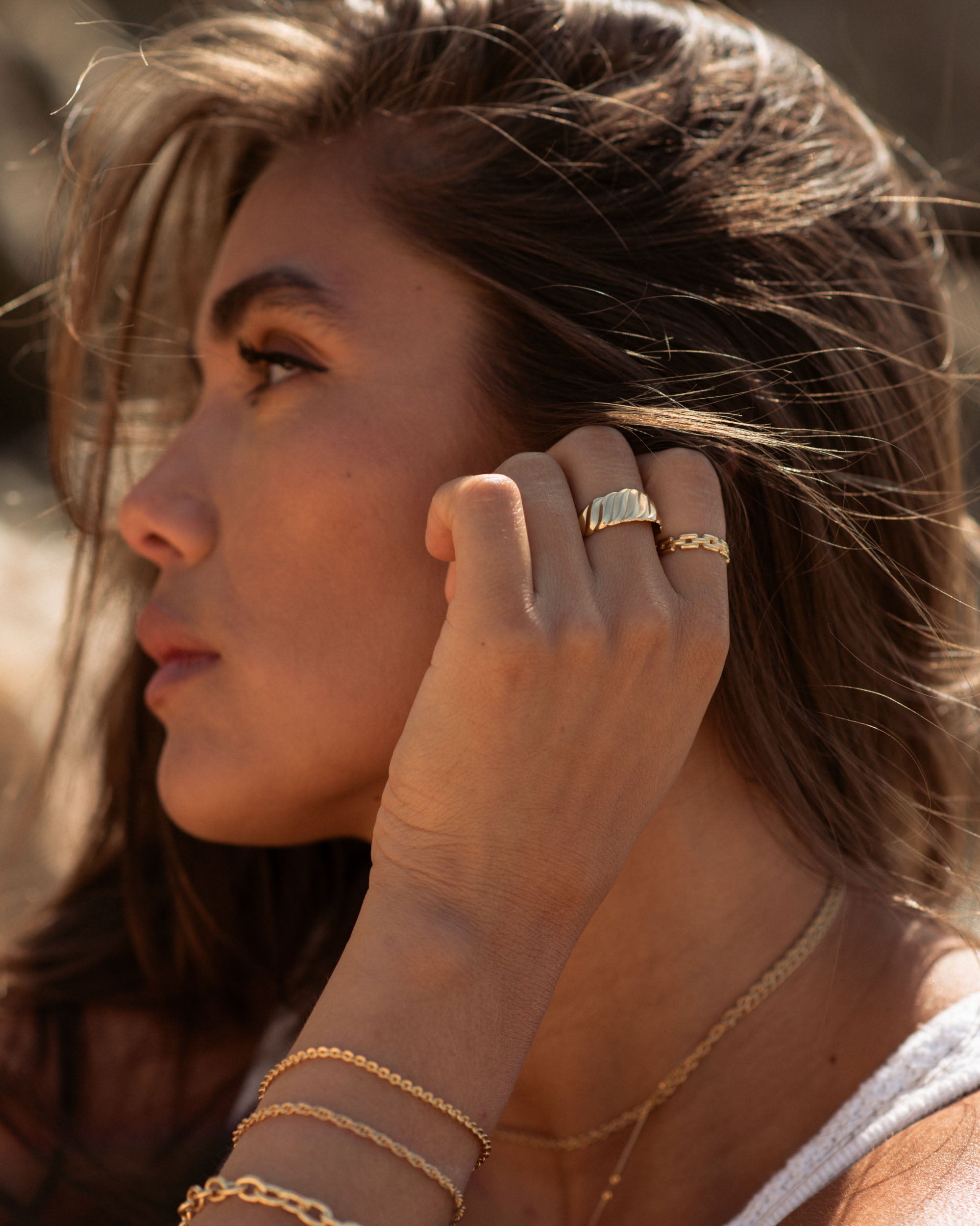 Set of jewels in 3-micron gold plating: a wide adjustable ring with a wavy motif, a fine adjustable ring with a square-chain motif, a sun-link bracelet, a rope-link bracelet, and a chain bracelet with wide links, made in France.