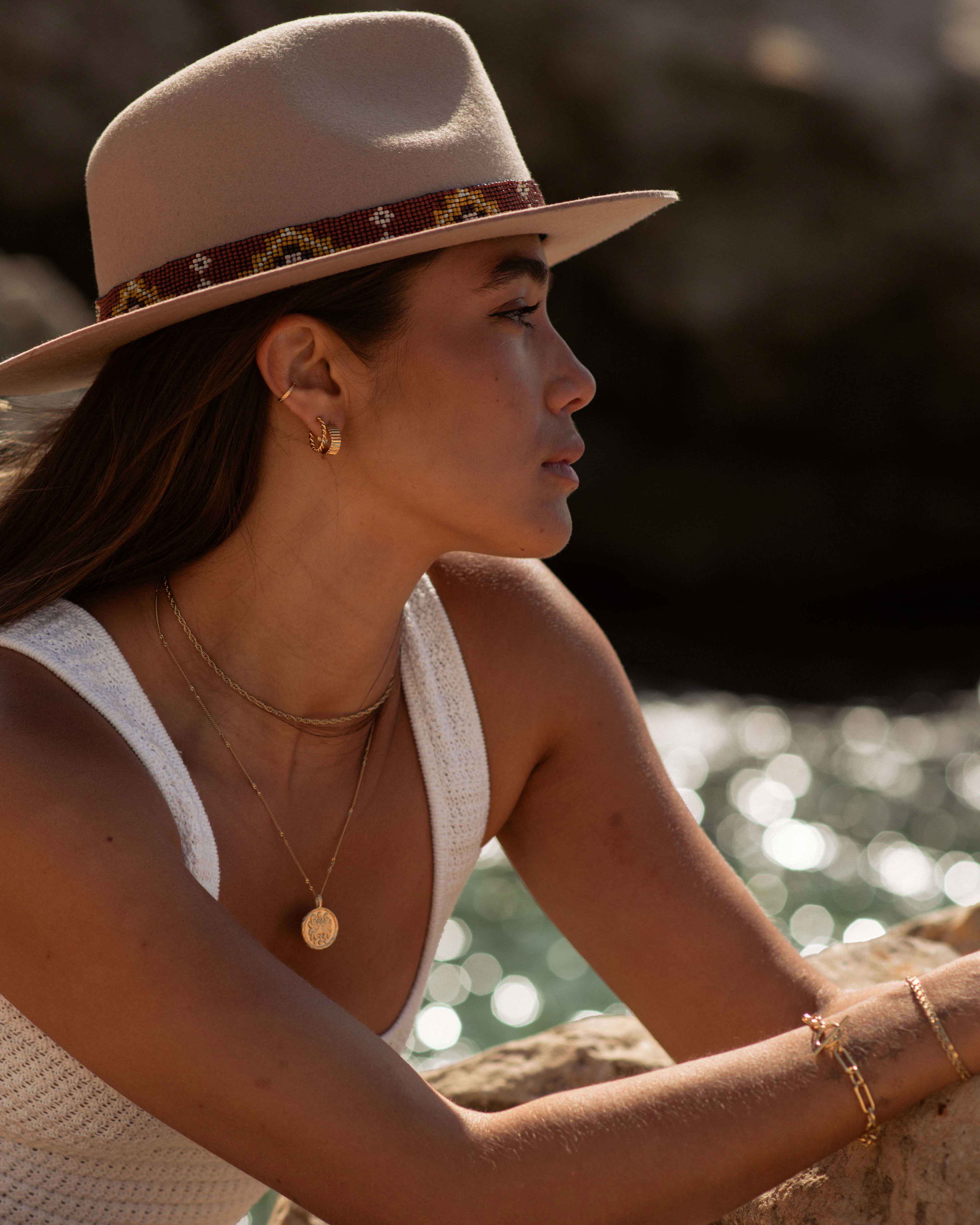 Set di gioielli placcati oro 3 micron: un earcuff sottile, una creola spessa con motivo a linee, una boucles con motivo intrecciato, poi una collana a maglia corda e un sautoir con pendente, un bracciale a catena larga, un bracciale a catena fine e un altro bracciale a catena piatta, Made in France.