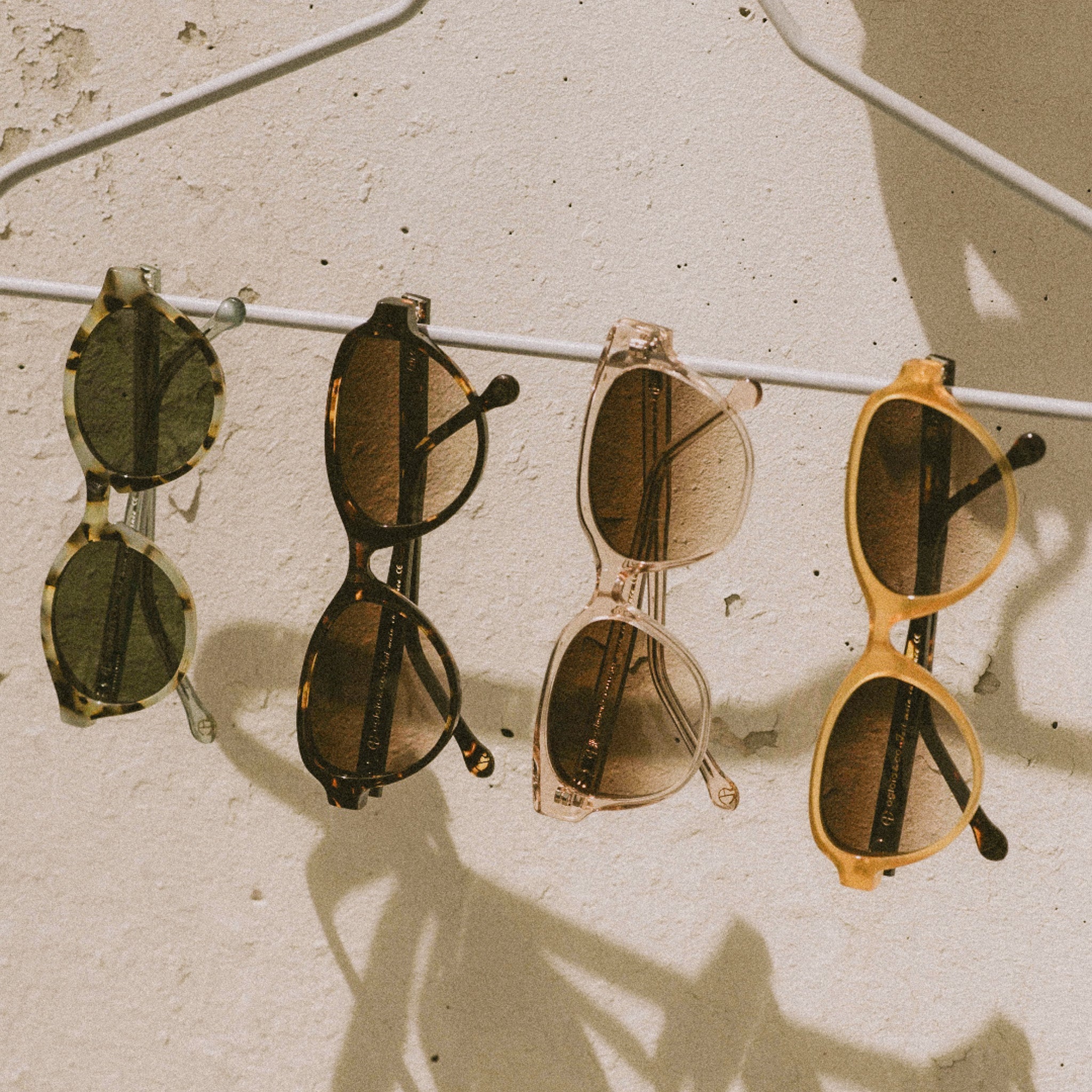 Femme qui porte des lunettes de soleil avec une serviette sur les cheveux et qui prend un bain de soleil en bord de mer.