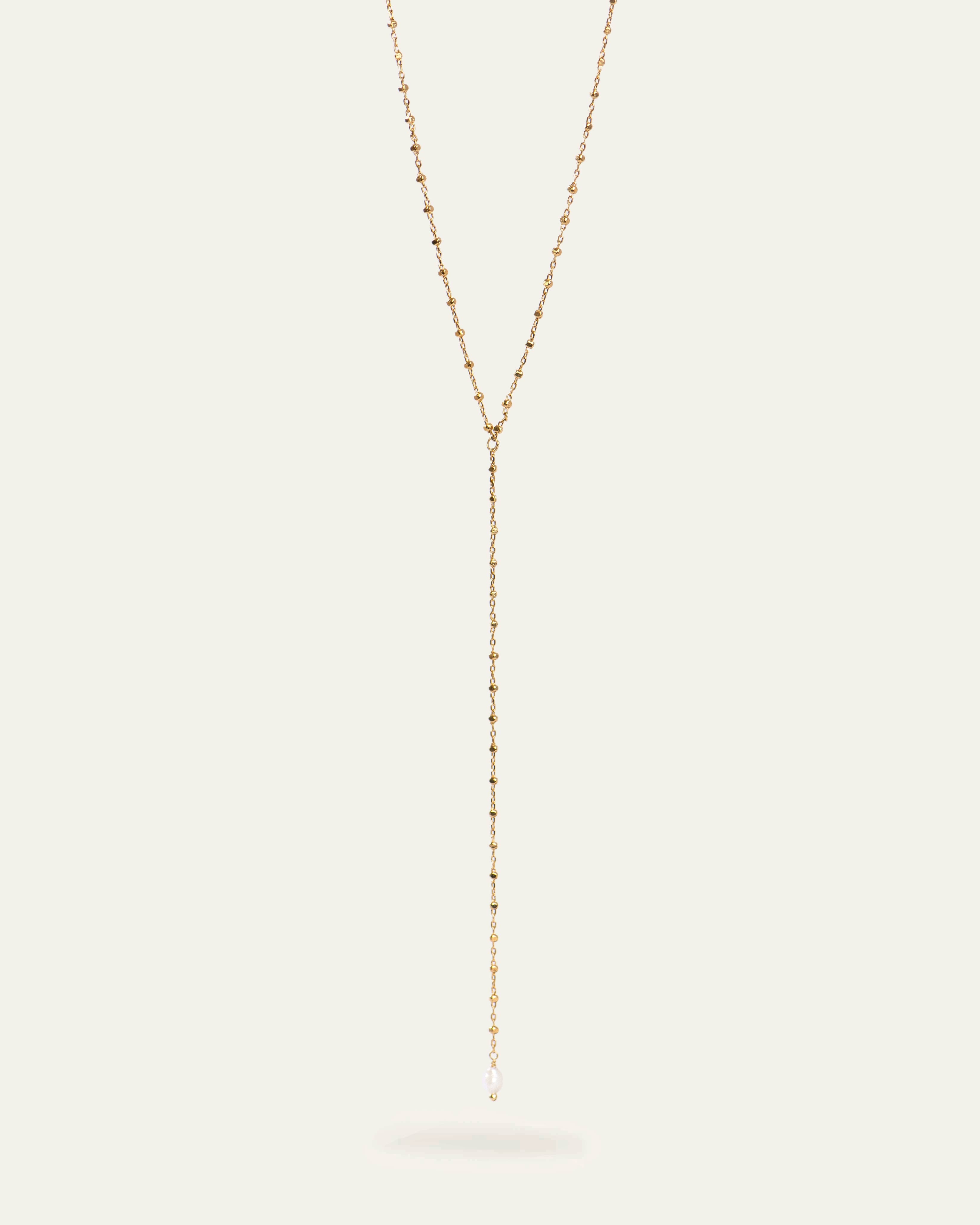 Collier en Y composé d'une chaîne fine avec des petites mailles carrées en plaqué or, et une petite perle de culture ovale made in France.