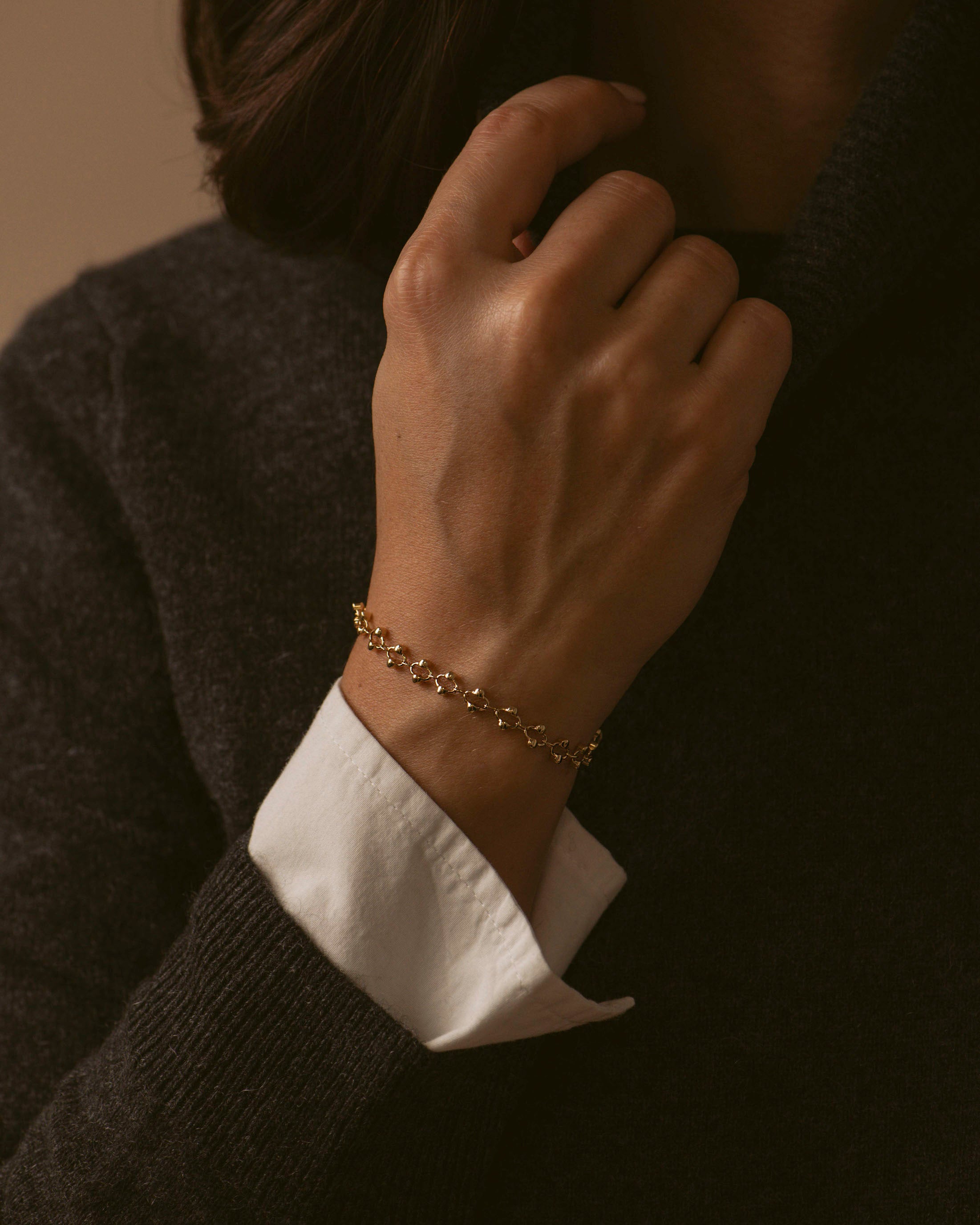 Bracelet élégant made in France, composé d'une chaîne avec des mailles ovales habillées de petites perles dorées sur les côtés, en plaqué or 18 carats.