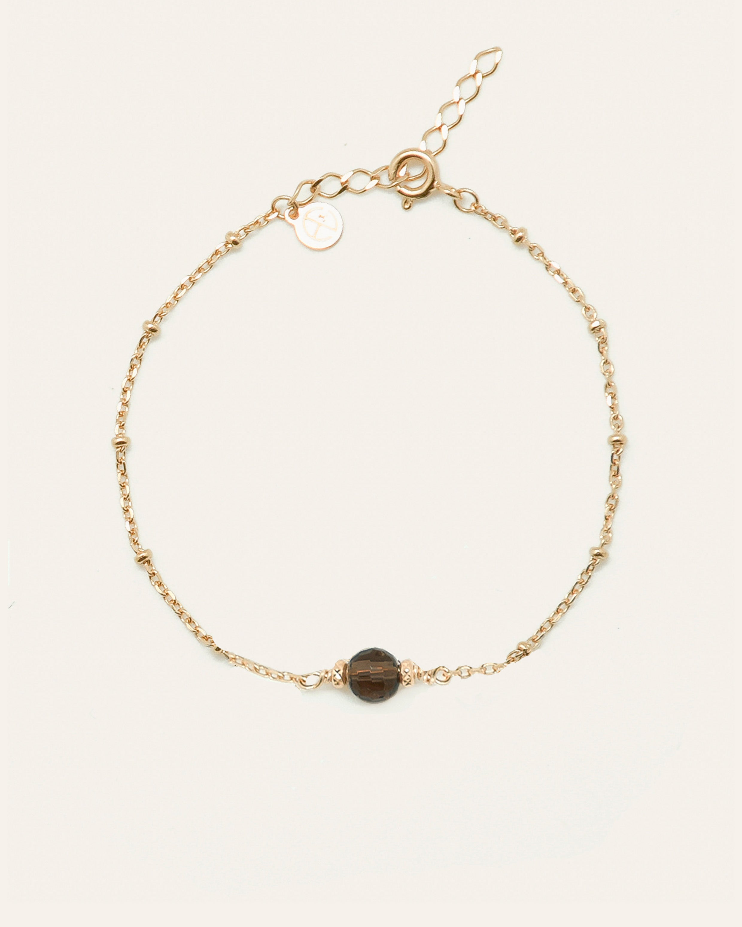Bracelet sur chaîne boule en plaqué or 3 microns composé d'une pierre de Quartz fumé ronde, et de deux petites boules en métal.
