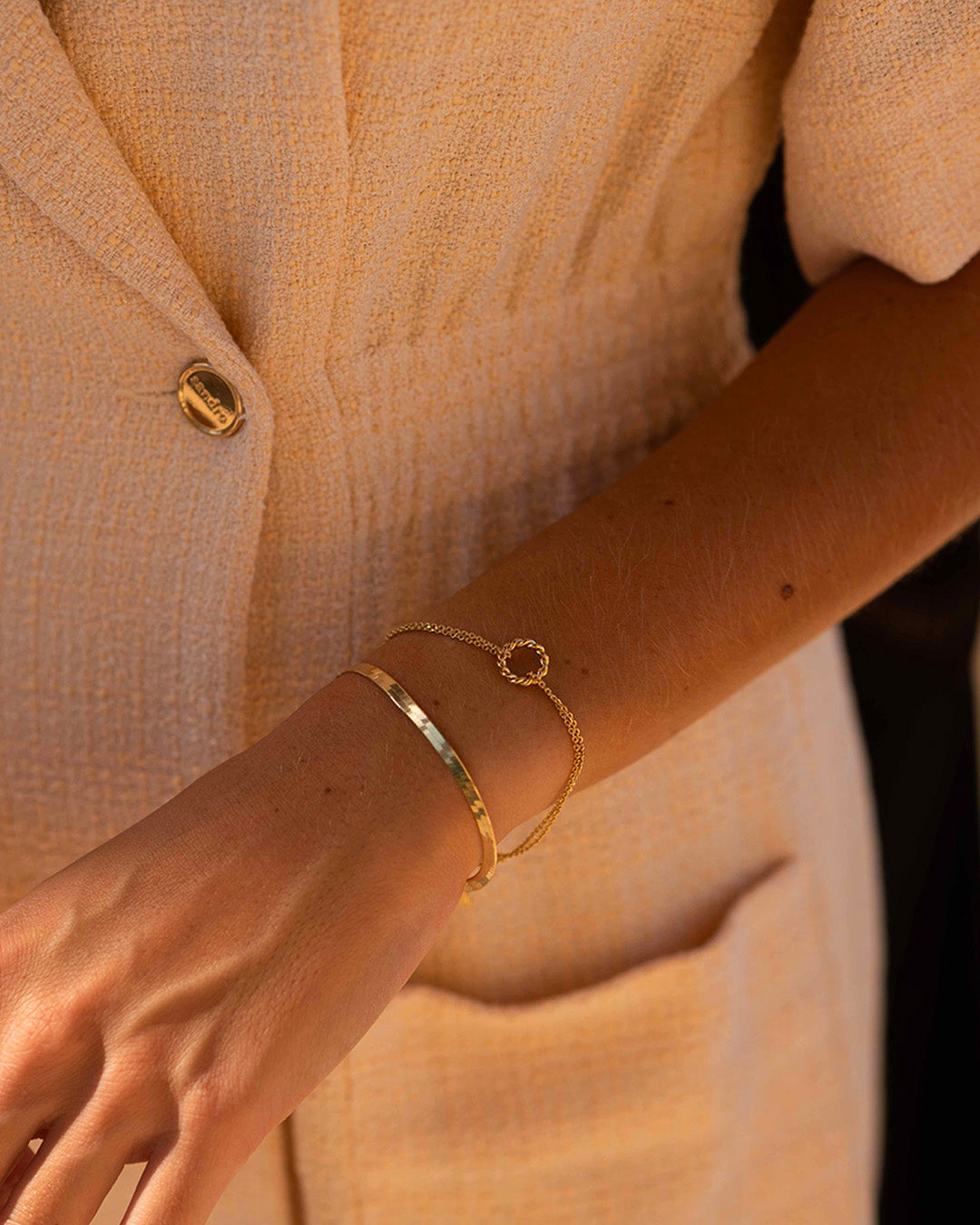 Association de bracelet en plaqué or 3 microns composée d'un bracelet en chaîne plate, et d'un bracelet fin en chaîne double avec un anneau torsadé fabriqués en France.
