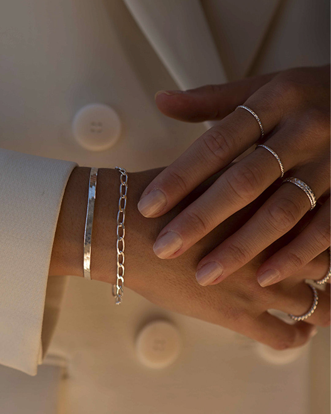 Association de bijoux éthiques en argent massif 925 composée d'un bracelet en chaîne plate, d'un bracelet en chaîne carré et de plusieurs bagues fines ajustables fabriqués en France.
