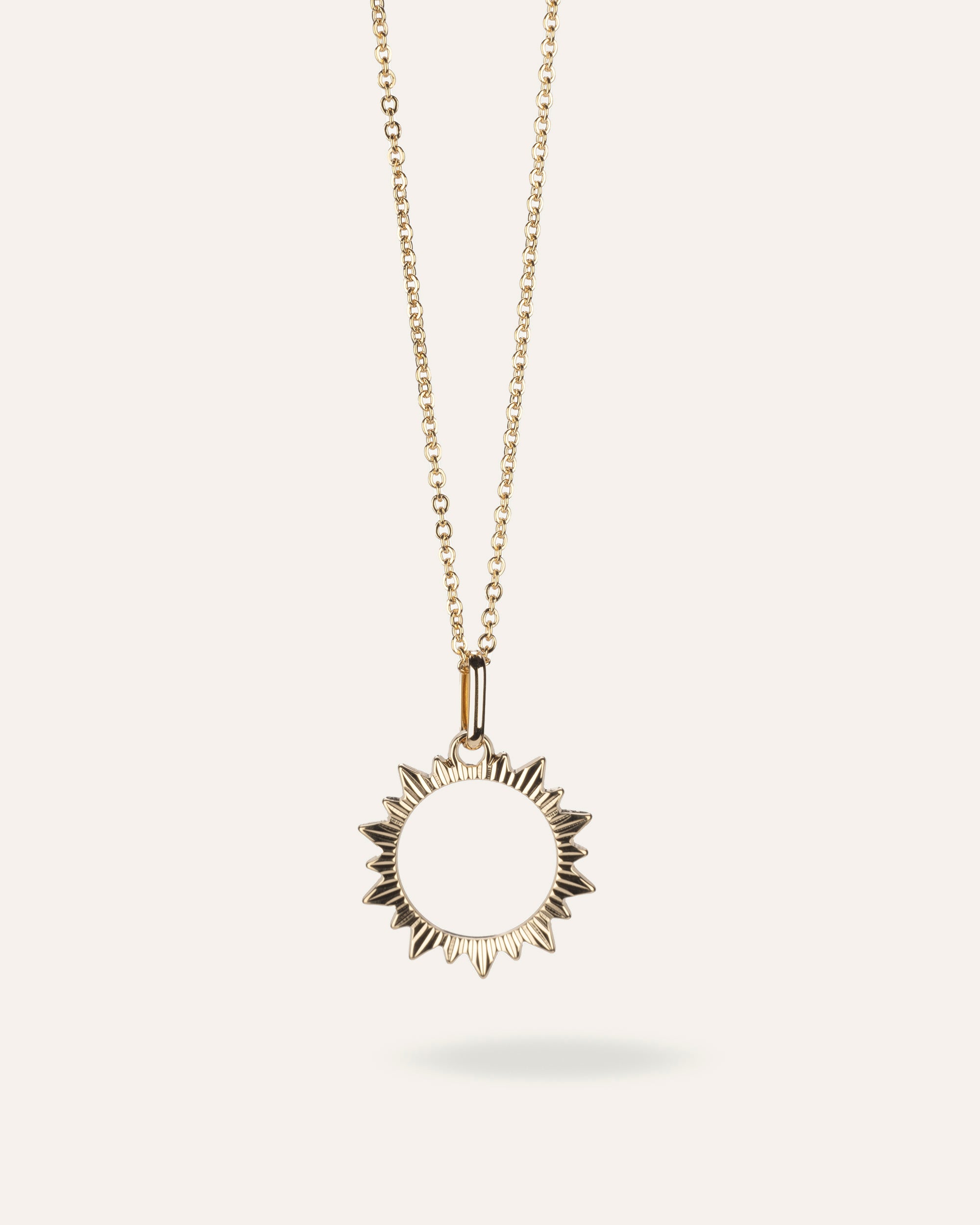 Collier fin en chaîne forçat avec un pendentif en soleil ajouré aux contours striés en plaqué or 3 microns made in France.