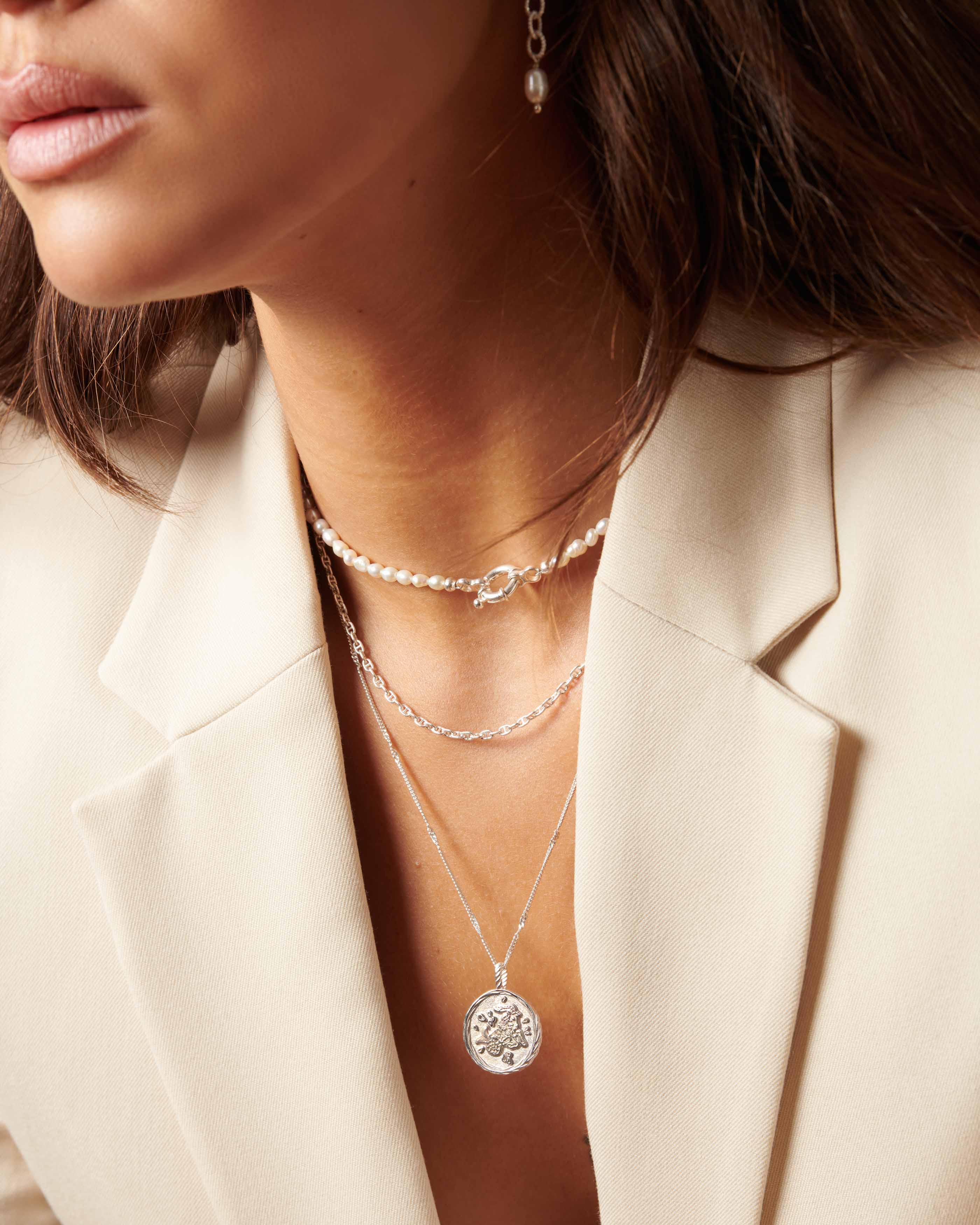 Association de 3 colliers en argent massif 925, composée d'un collier en perles de culture ras de cou, d'une chaîne marine et d'un collier fin avec un pendentif au signe astrologique Capricorne made in France.