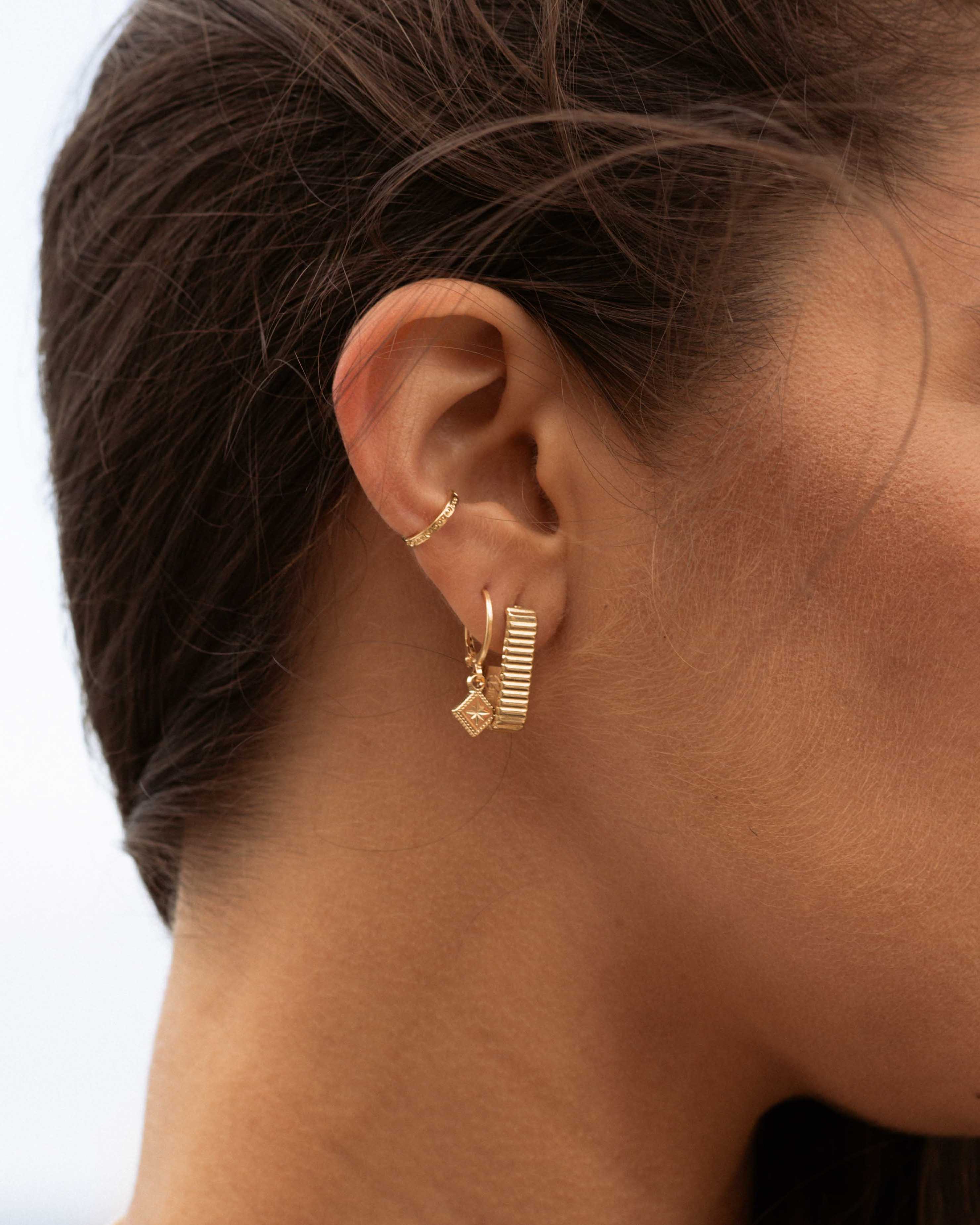 Association de boucles d'oreilles en plaqué or 3 microns composées d'un anneau d'oreille fin, d'une boucle pendante avec un anneau et un losange, et d'une boucle rectangle avec des motifs en ligne made in France.